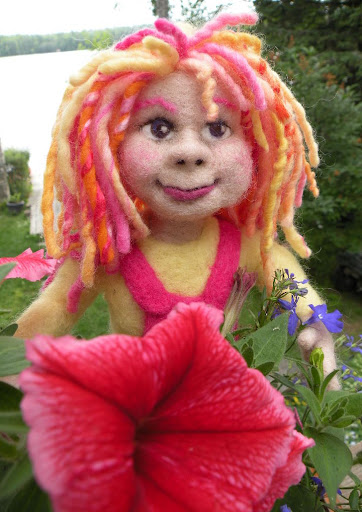 needle felted doll, Daisy, in the flower bed
