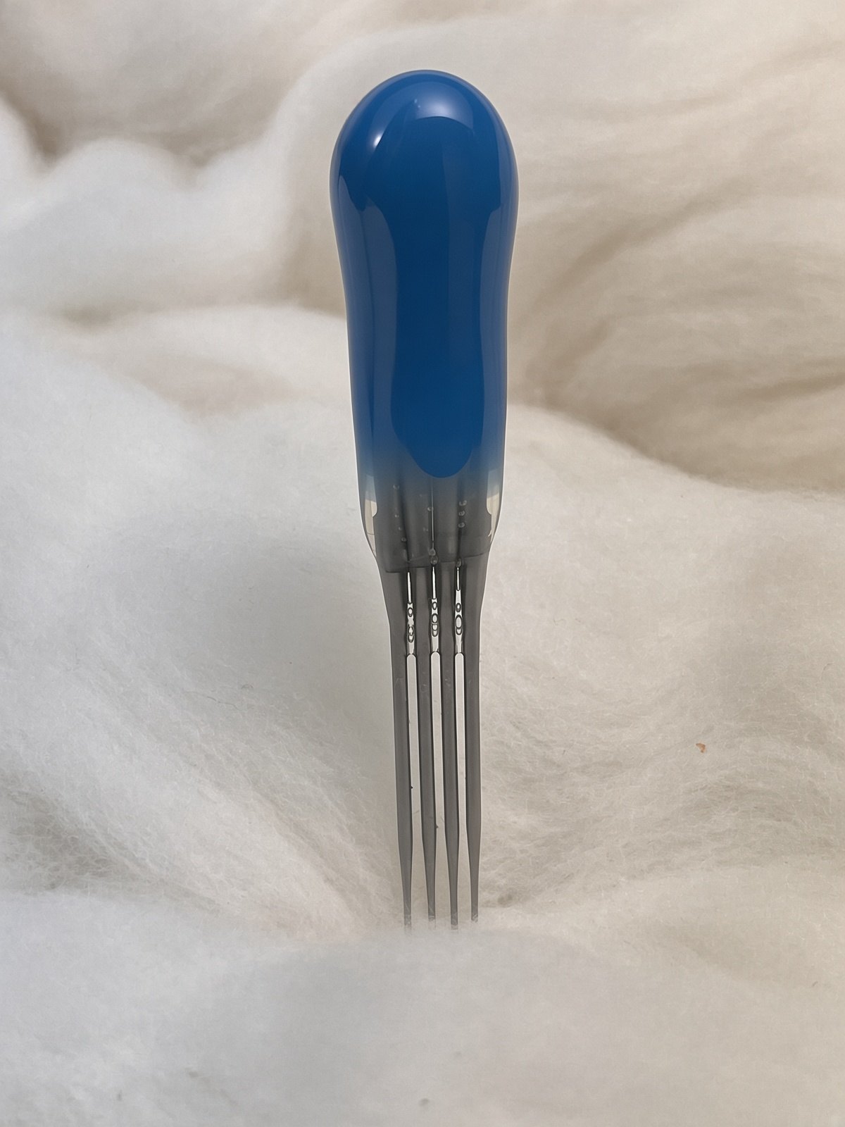 Felt Alive blue quad felting needle with four steel points and glossy handle on wool