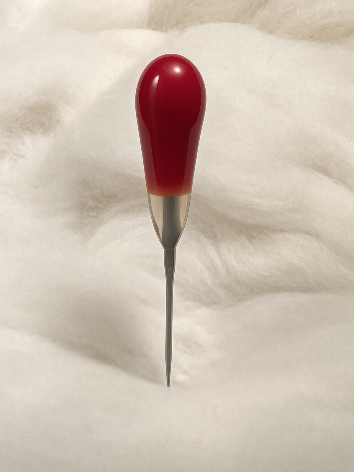 Felt Alive red single felting needle with glossy teardrop handle on wool